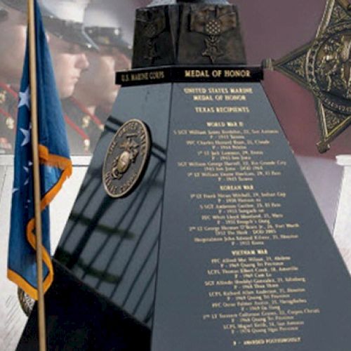 The image features a US Marine Corps Medal of Honor Memorial with names listed, surrounded by Marine personnel and medal depictions.